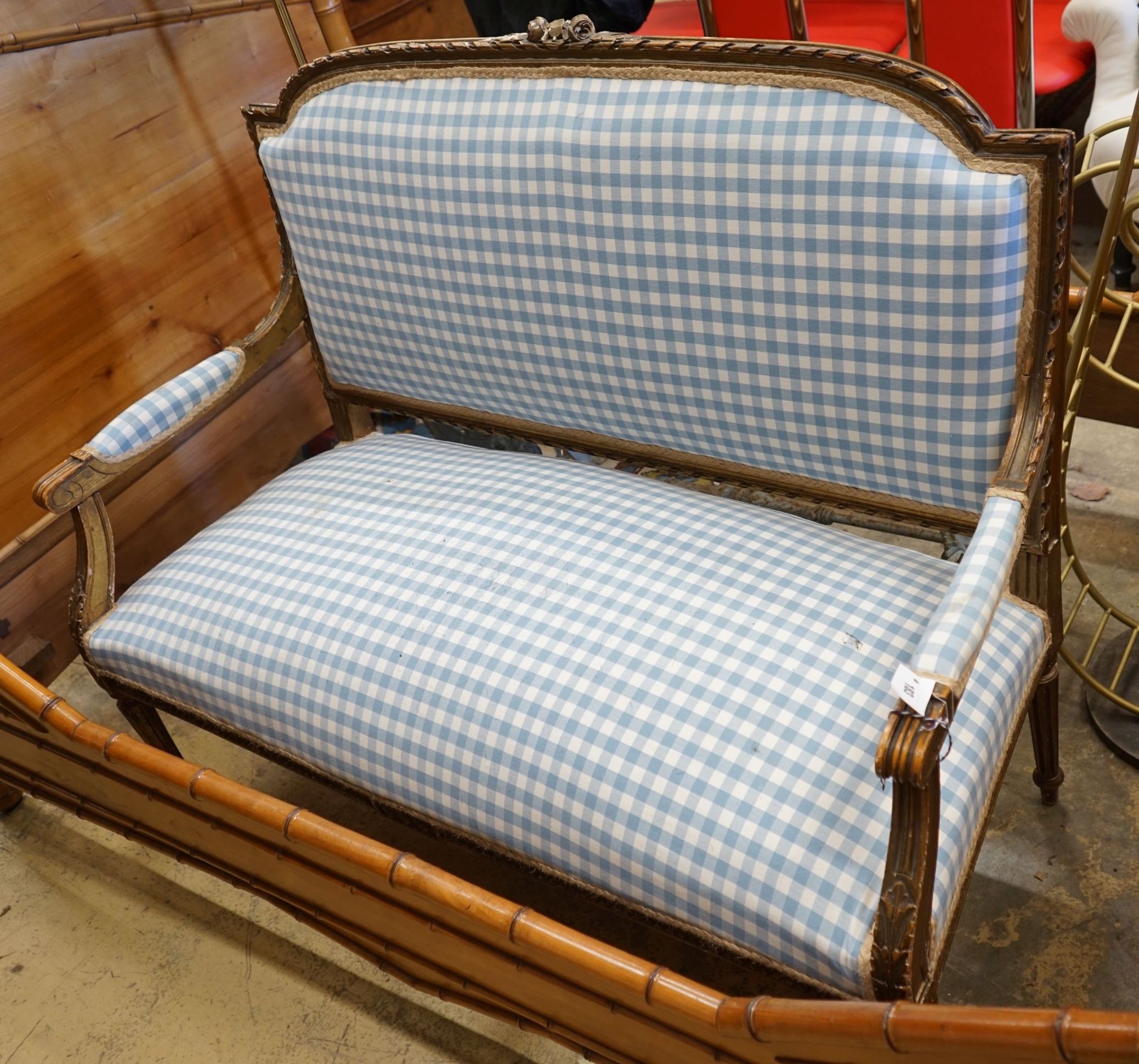 A 19th century French carved giltwood settee recently re-upholstered in blue gingham fabric, width 130cm depth 55cm height 102cm